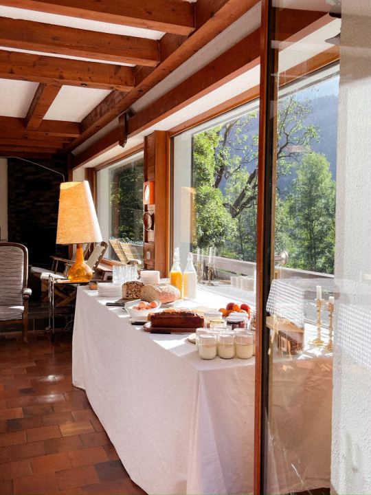 Le buffet du petit déjeuner dressé devant la baie vitrée