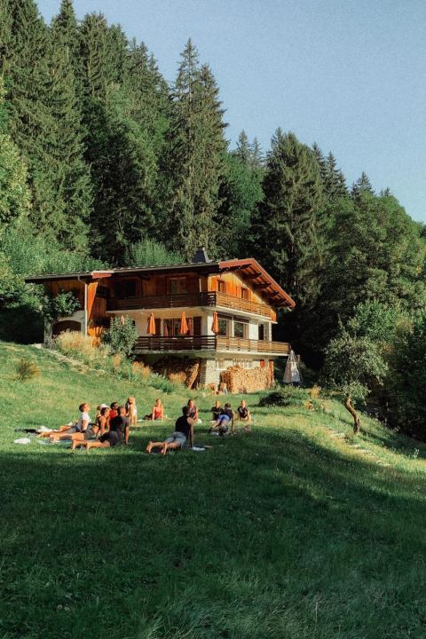 Séance de yoga en groupe dans le jardin, devant le chalet